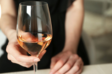 Woman holding glass of wine, closeup