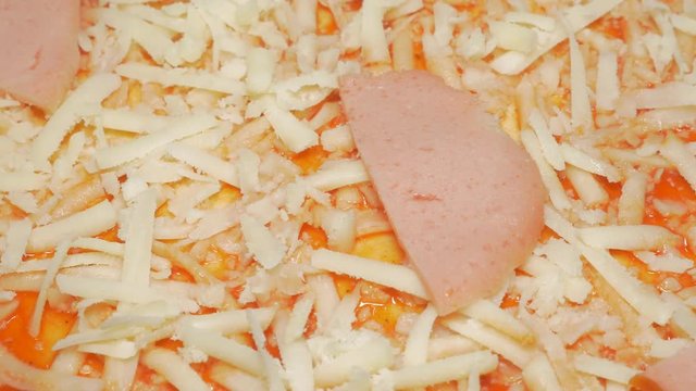Cheese parmesan pieces and salami on pizza base 4K 3840X2160 UHD slow panning video - Cheese sprinkled and salami cuts on pizza base 4K 2160p UHD footage 