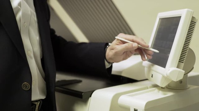 businessman pressing the touch screen of a large printer 4k