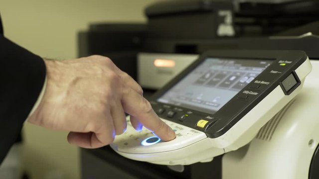 businessman pressing the touch screen if a large copier 4k