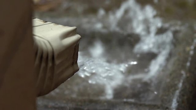 slow motion rain coming out of a home downspout