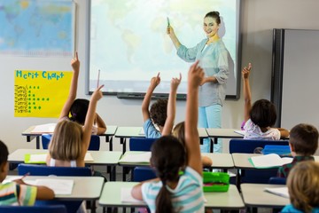 Teacher teaching schoolchildren using projector screen 
