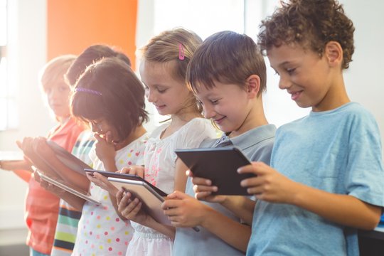 Smiling children using digital tablets  - Powered by Adobe
