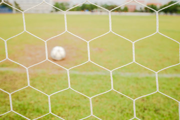 soccer goal net with green field background.