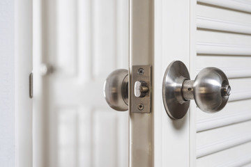 Close-up stainless door knob, with door open slightly