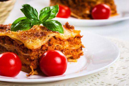 Piece of tasty hot lasagna with red wine..