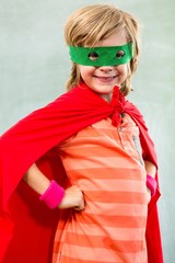 Smiling boy dressed as superhero in classroom - obrazy, fototapety, plakaty