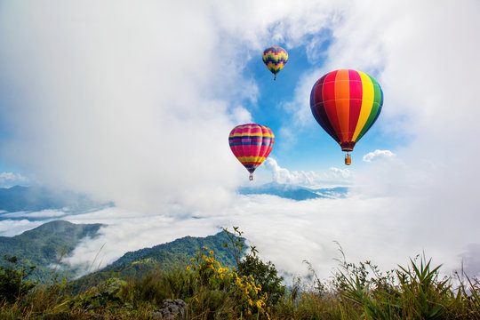 Colorful hot-air balloons flying over the mountain at Pha Tung,Chiangrai province ,North of Thailand.