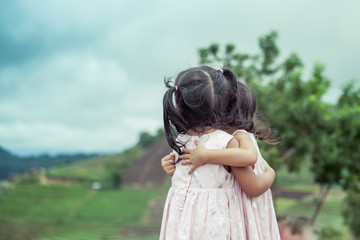 Obraz premium Child two little girls hug each other with love in the park