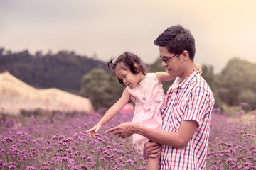 father and daughter having fun in the flower garden