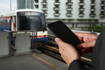 Woman hand hold and touch screen smart phone, tablet,cellphone on blurred abstract electric train background as technology and travel concept.