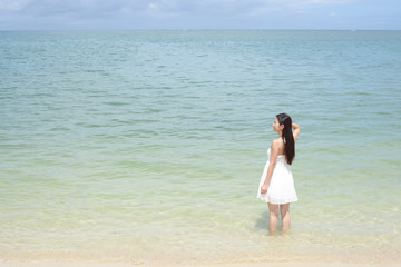 Fototapeta na wymiar 沖縄の美しいビーチで寛ぐ女性