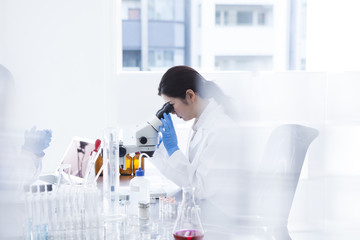 Woman looking through a microscope in a laboratory