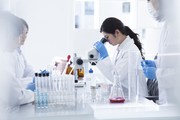 Woman looking through a microscope in a laboratory