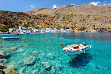 Small motorboat at clear water bay of Loutro town on Crete island, Greece - obrazy, fototapety, plakaty