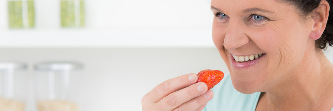 frau isst frische erdbeeren