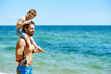 Naklejka premium Father and son on the beach with underwater equipment . Father teaches son how to swim