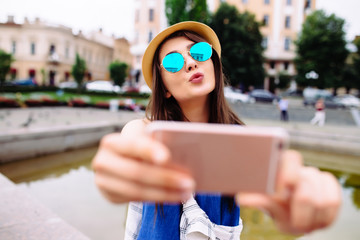 Girl send kiss on selfie photo. Urban life concept.