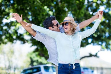 Obraz premium Couple with arms outstretched against trees