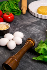 Vegetables and dough over grey wooden background