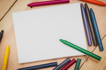 Crayon with paint canvas on wood background with copy space