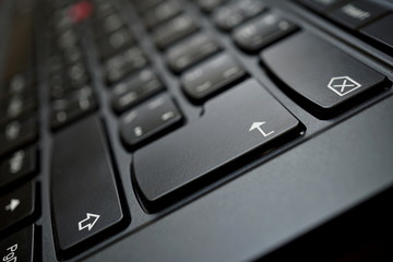 Detail of a brand new modern black laptop keyboard with the focus on the Enter key