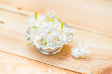 Fototapeta na wymiar jasmine flower on silver tray, Thai white flower on wood background.