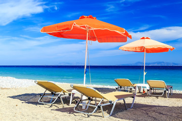 Fototapeta na wymiar Empty sun loungers on the beach before summer