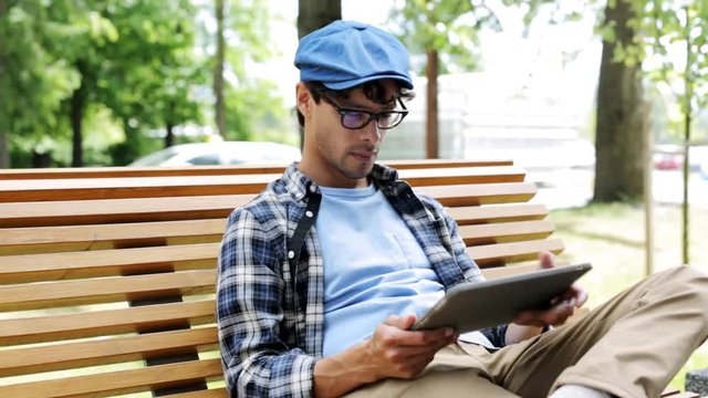 man with tablet pc sitting on city street bench 7