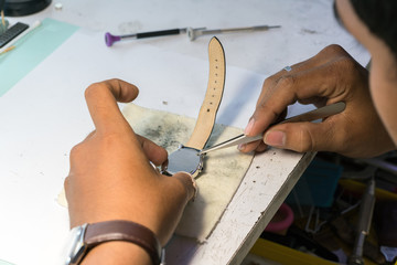 Clockmaker repairing wrist watch
