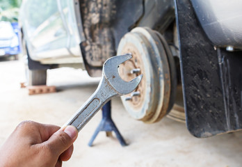 Hand hold wrench fix a car.