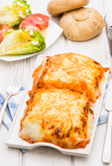 lasagna baked in porcelain tray on wooden