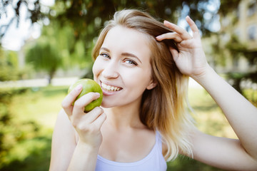 gren apples.smiling woman with apple, outdoors, Healthy eating concept.Close up