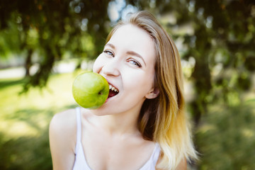 gren apples.smiling woman with apple, outdoors, Healthy eating concept.Close up