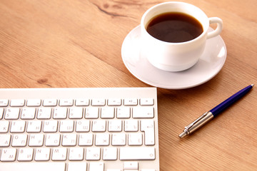 Office table with blank notepad and laptop