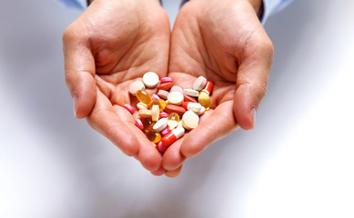 A young doctor holds the patient's hand with pills