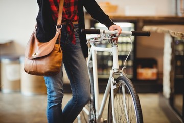 Mid section of woman standing along with bicycle - Powered by Adobe
