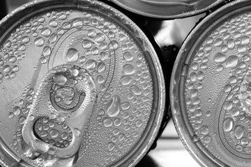 pop cans with drops of water in black and white