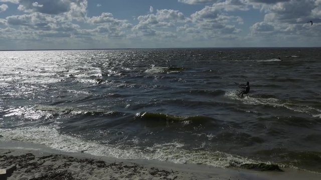 Kite surfing on the sea. Slow panning panorama shot.