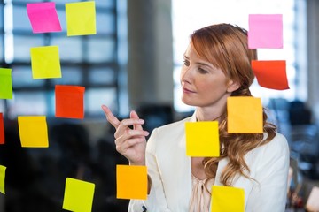 Businesswoman pointing at sticky notes