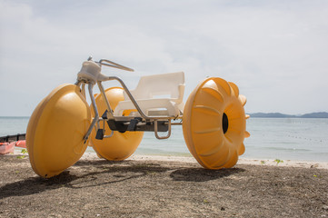 AF focused of yellow water tricycle on the beach with Andaman sea with blue sky background,Phuket,Thailand