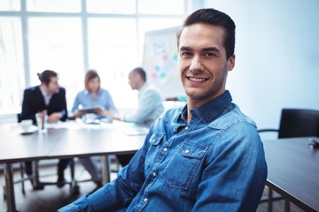 Businessman sitting against colleagues in meeting room