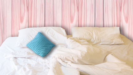 white pillow and blue pillow on bed and with wrinkle messy blanket in red vintage bedroom, from sleeping in a long night.