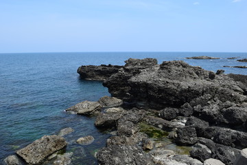 Fototapeta na wymiar 庄内海岸の岩場風景 ／ 山形県で庄内海岸の岩場風景を撮影した写真です。庄内海岸は非常にきれいな白砂と奇岩怪石の磯が続く、素晴らしい景観のリゾート地です。日本海トップランクのリゾート地として、五感の全てを満たす多くの魅力にあふれたエリアです。