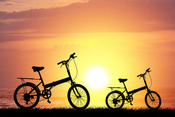 Fototapeta na wymiar Bike silhouette on the grass.Blurred background sunset