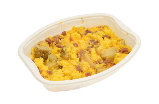 Ham eggs and potatoes breakfast TV dinner in a tray isolated on a white background.