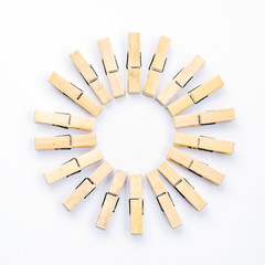 Group of wooden clothespins arranged in a circle isolated on white background.