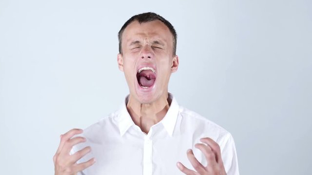 Close-up of angry businessman screaming against blue background