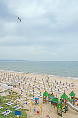 The seaside, Black Sea shore with gold sands, umbrellas, blue water and sunbeds.