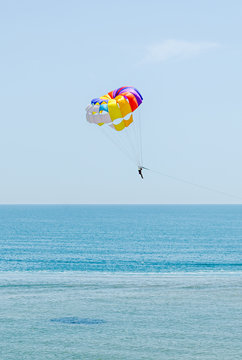 Colored parasail wing in the blue sky, sea water, close up